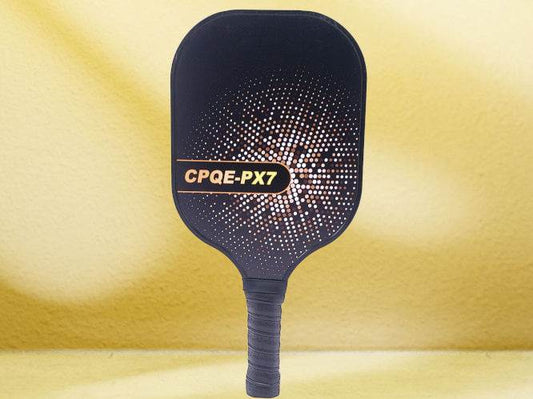 CPQE PX7 Gold Carbon Fiber Pickleball Paddle with sleek design and textured grip, on yellow background.