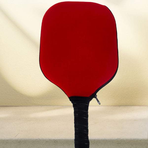 Red pickleball paddle cover protecting paddle from scratches.